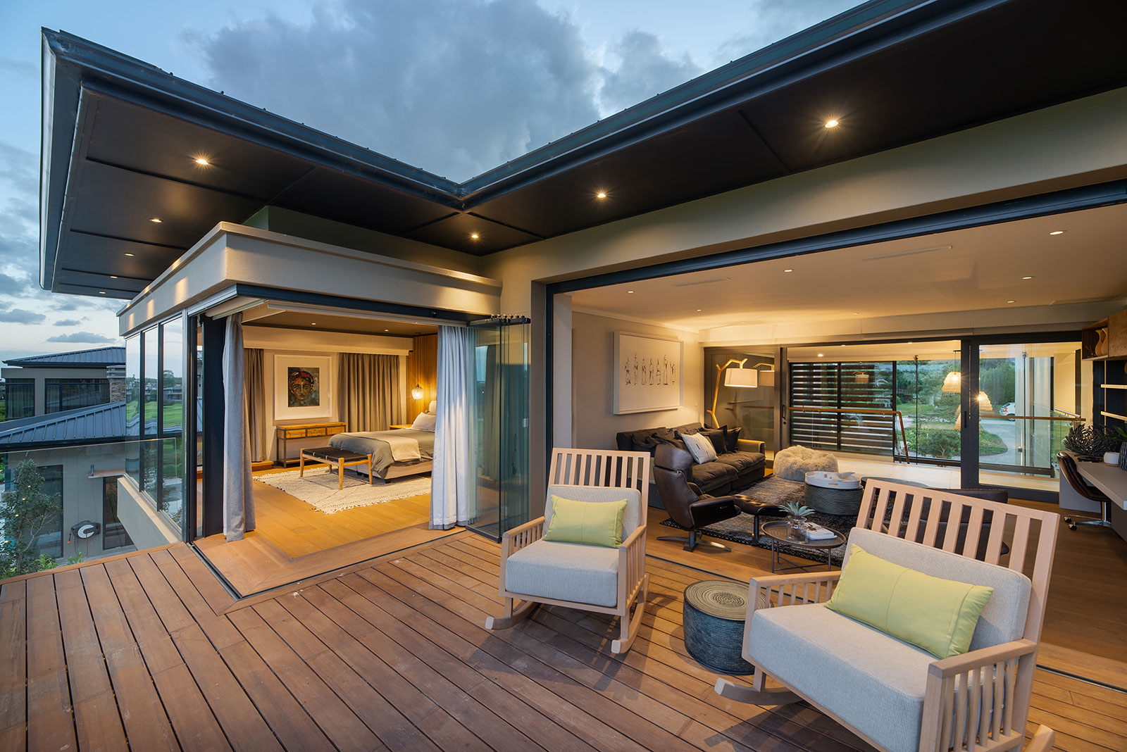 Upper deck with bedroom and lounge connected to outdoor seating under extended eaves