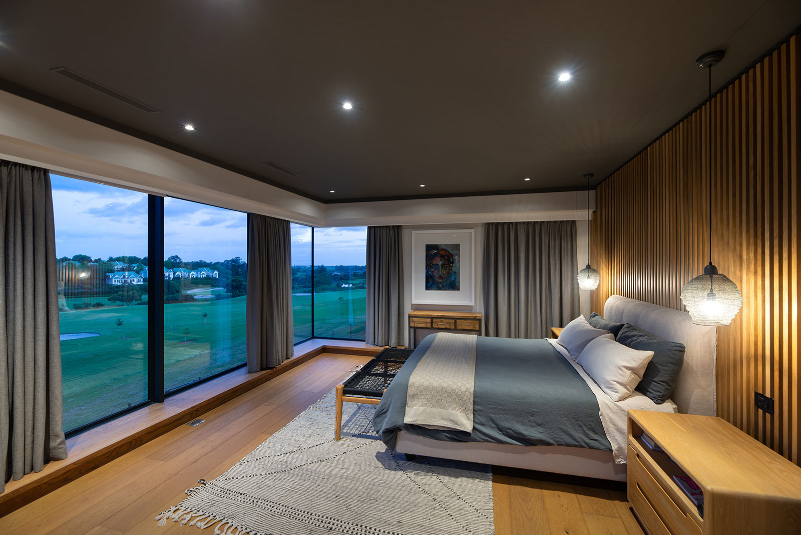 Corner main bedroom with full height glazing overlooking the golf course