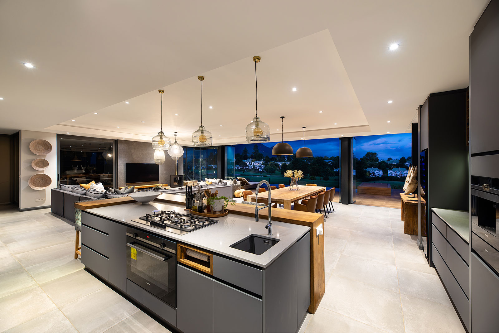 Kitchen island with integrated hob and breakfast counter facing the open plan living area