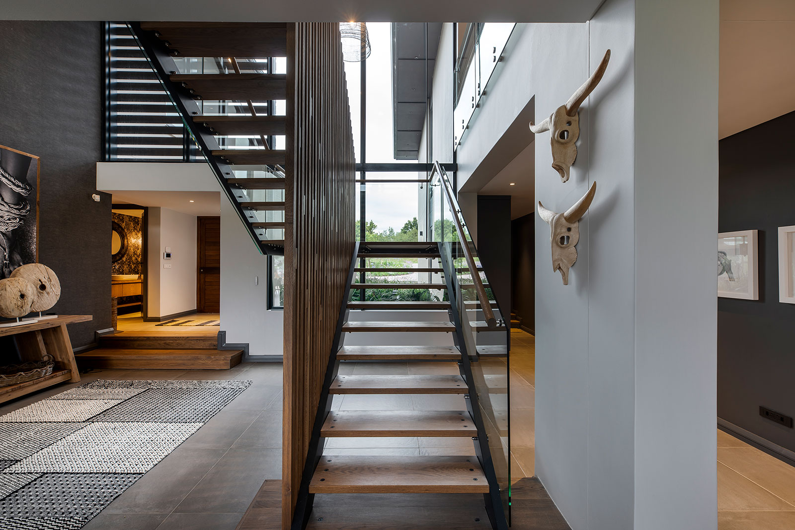 Double volume entry hall with central timber and glass staircase exemplifying contemporary fancourt architecture