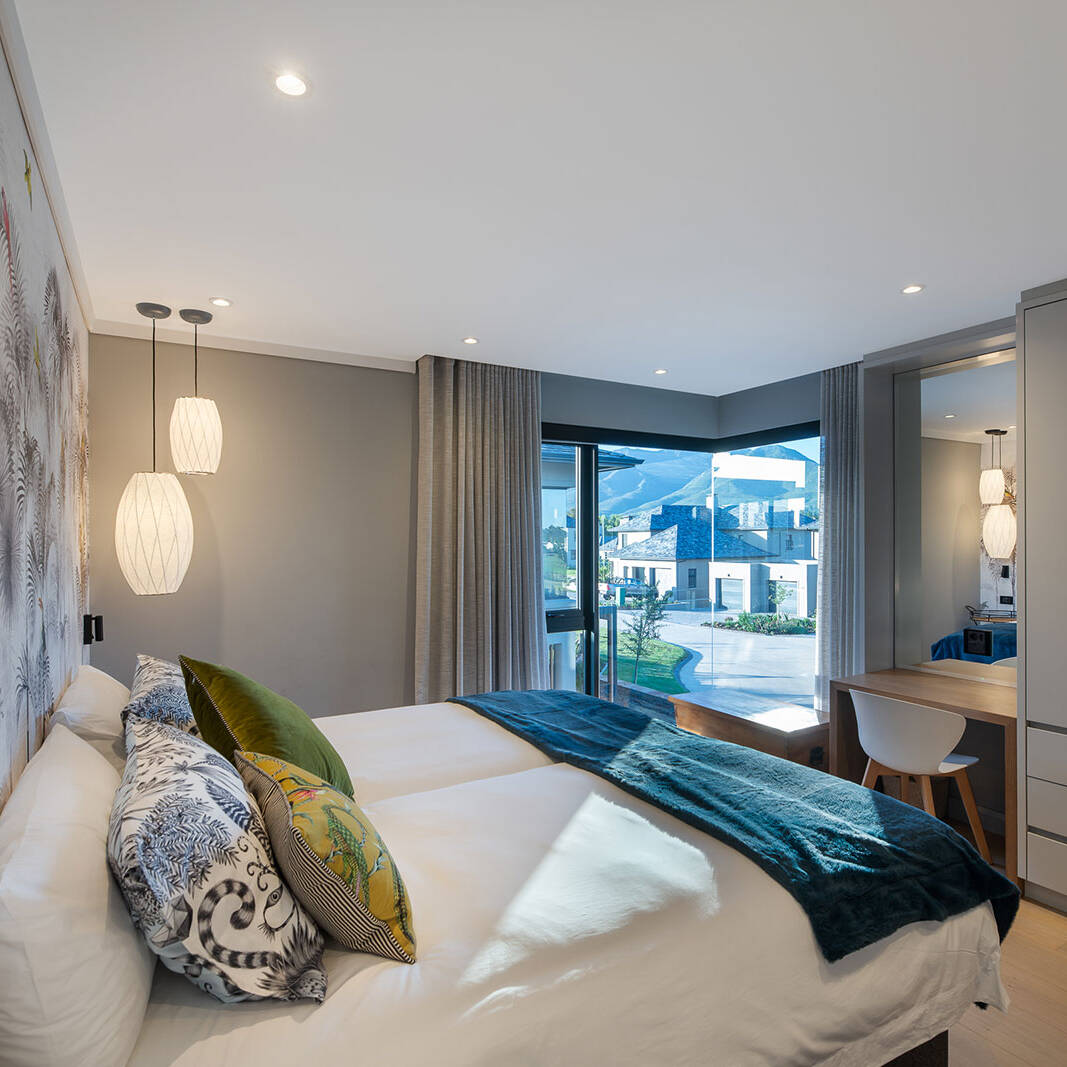 Guest bedroom with bay window and patterned feature wall