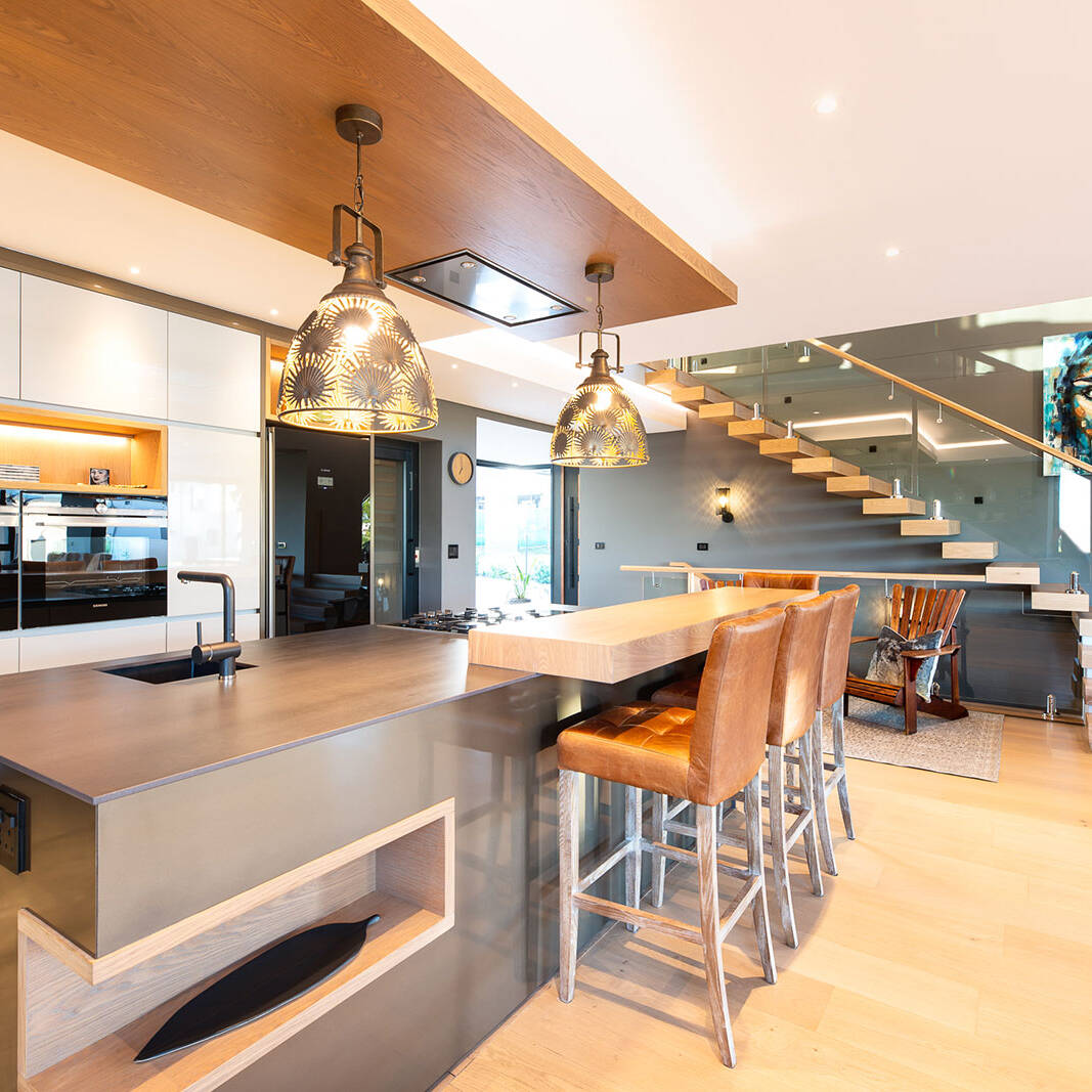 Kitchen with island breakfast counter and floating stair in open plan space