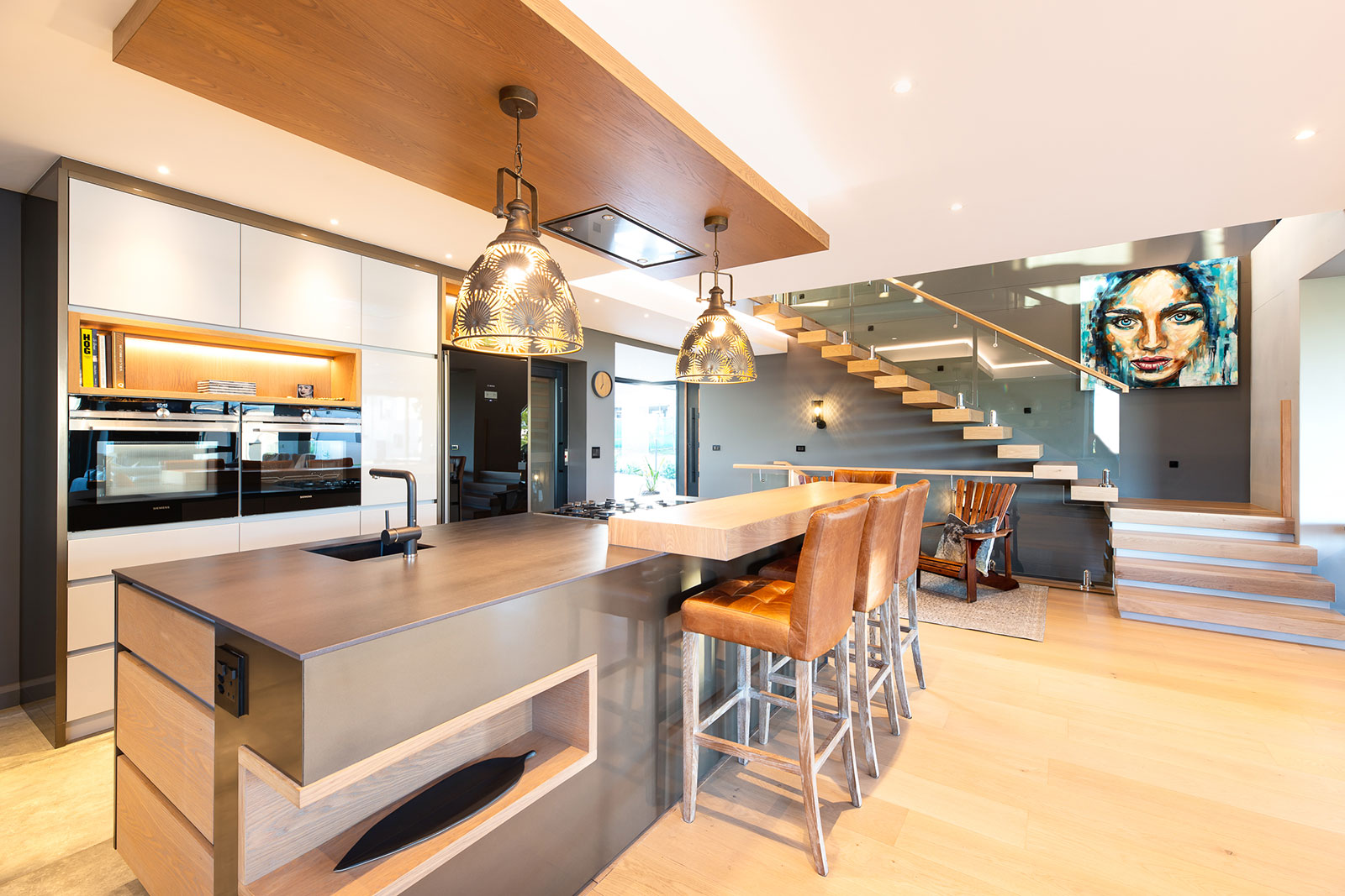 Kitchen with island breakfast counter and floating stair in open plan space