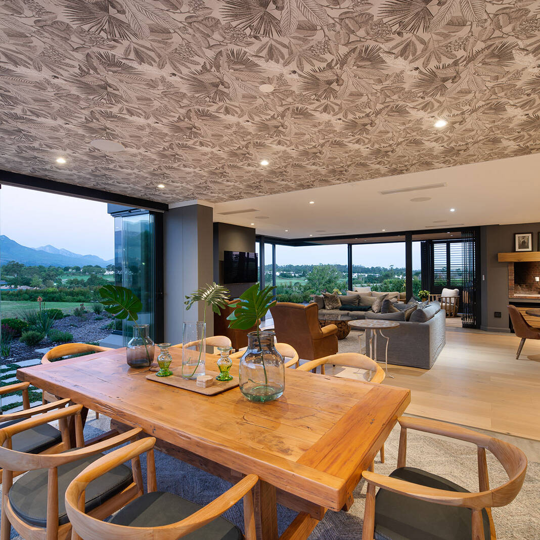 Family living area with patterned ceiling and sliding doors to patio