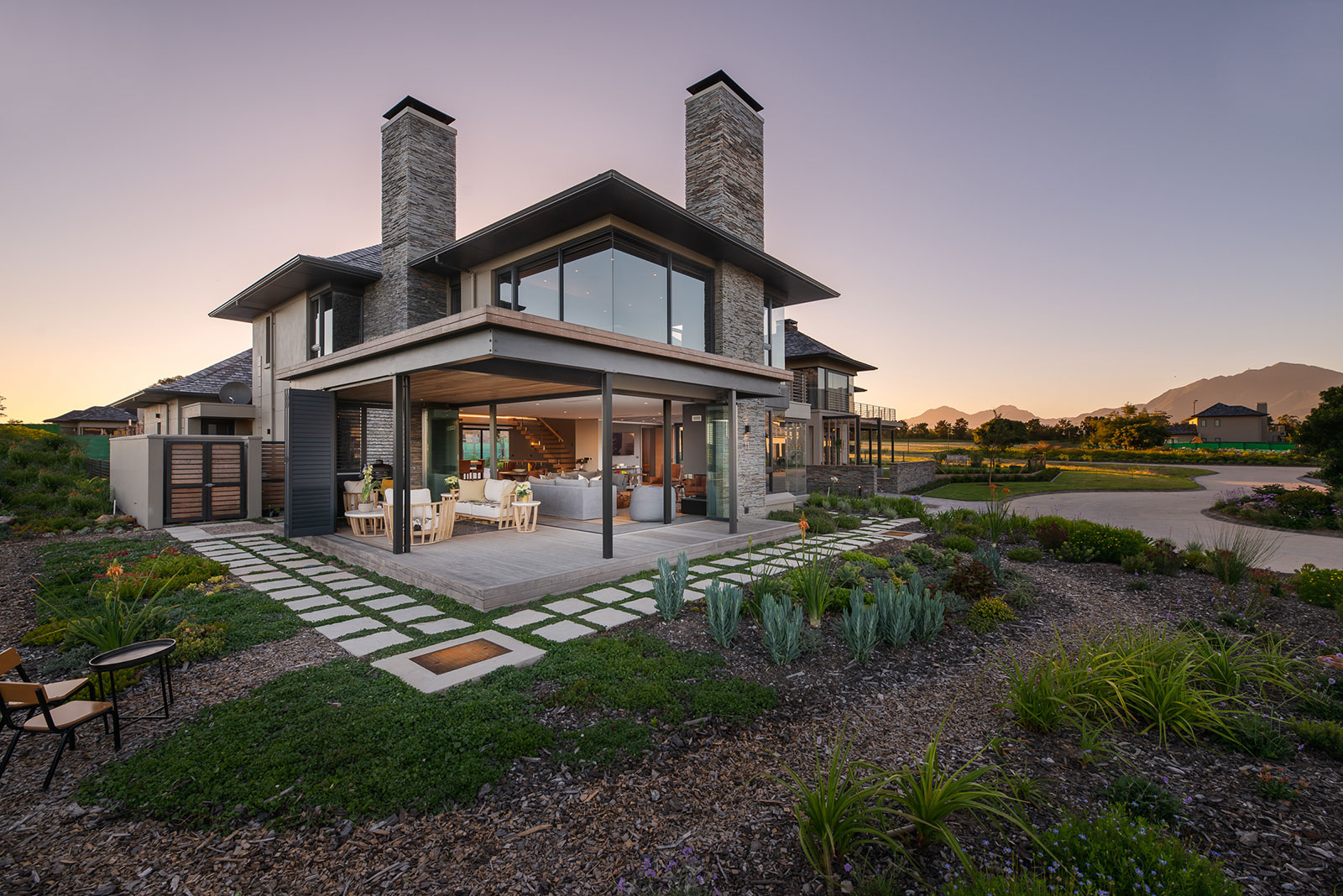 Evening exterior with stone cladding and folding doors to terrace