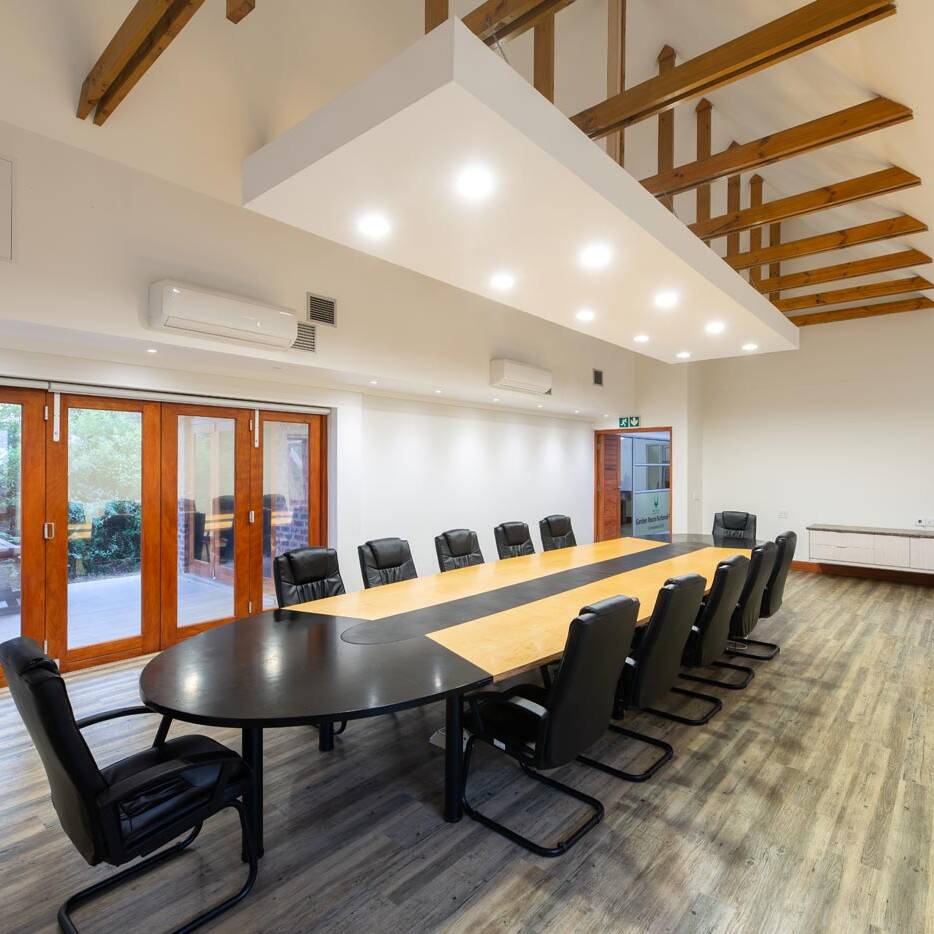 Boardroom with long table, timber doors and exposed trusses in The Eastern Cape.