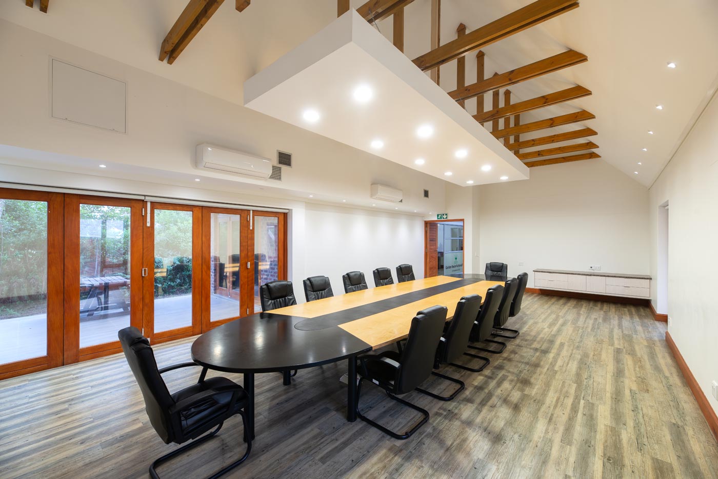 Boardroom with long table, timber doors and exposed trusses in The Eastern Cape.