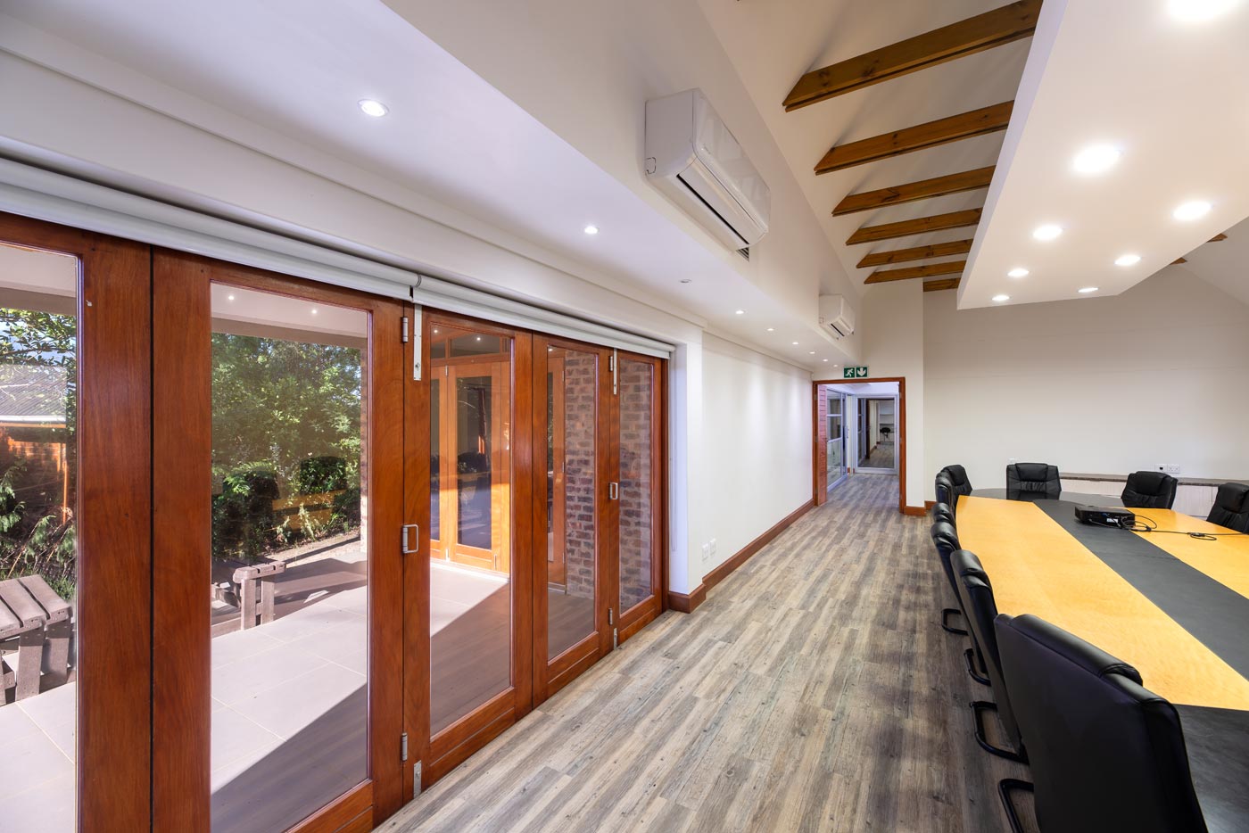 Boardroom opening to glazed timber doors and landscaped veranda
