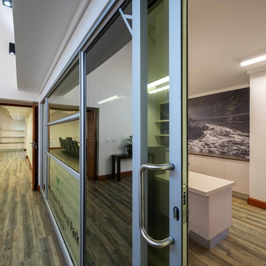 Office corridor with glass partition and sliding door to meeting suite
