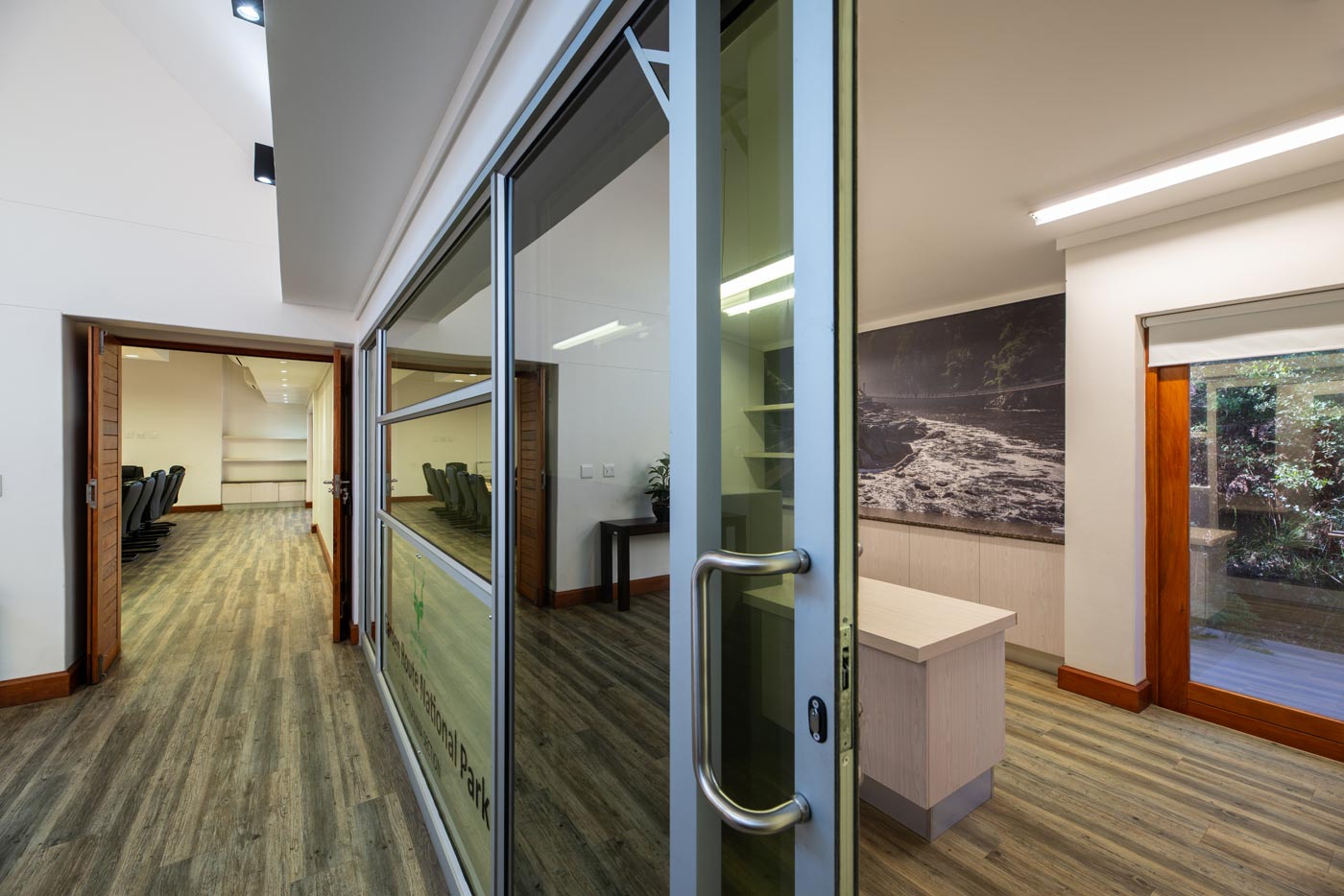 Office corridor with glass partition and sliding door to meeting suite