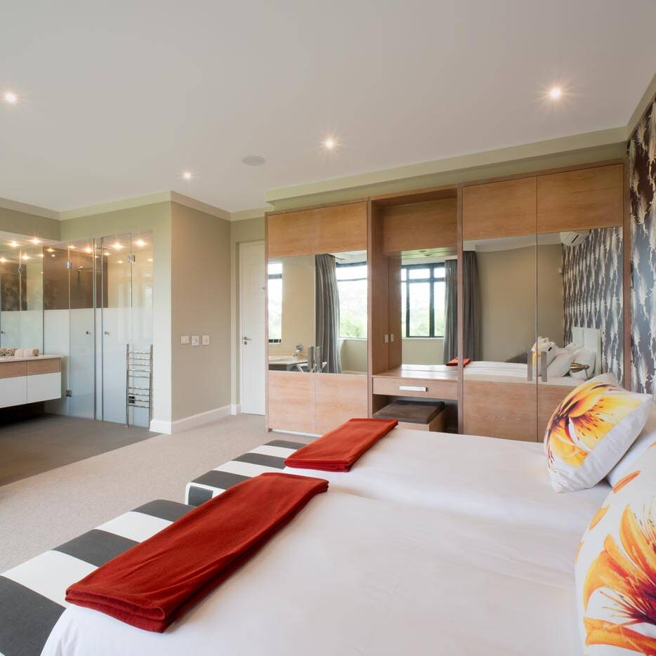 Master suite with open bathroom mirrored wardrobes and patterned feature wall