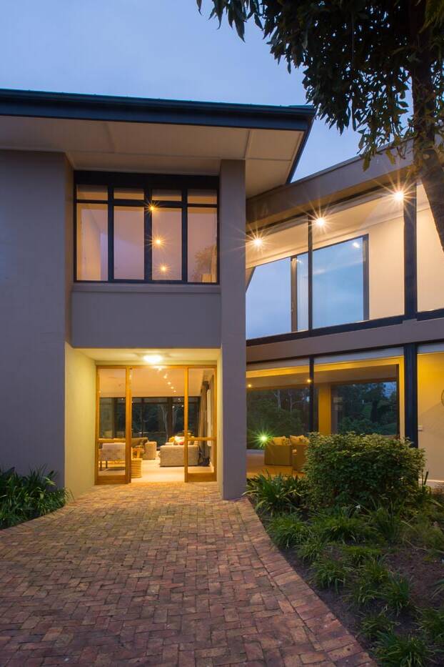 Evening view of glazed entrance court and upper walkway