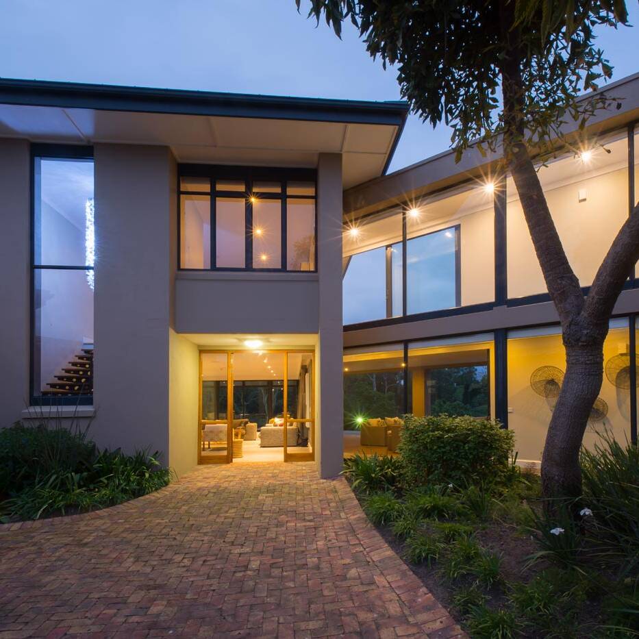 Evening view of glazed entrance court and upper walkway