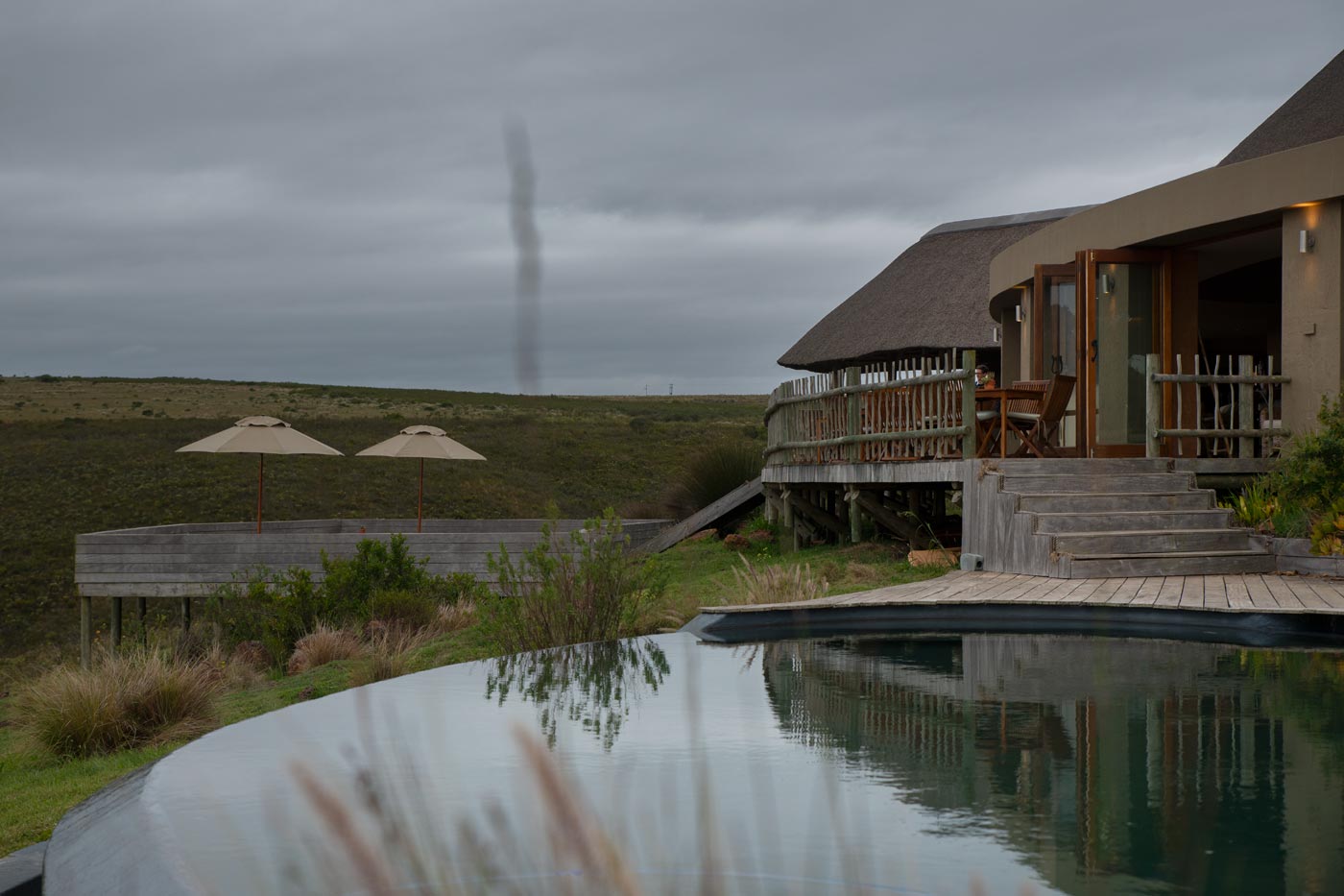 Timber deck and thatched gazebo outside the main lodge with valley views in the Garden Route
