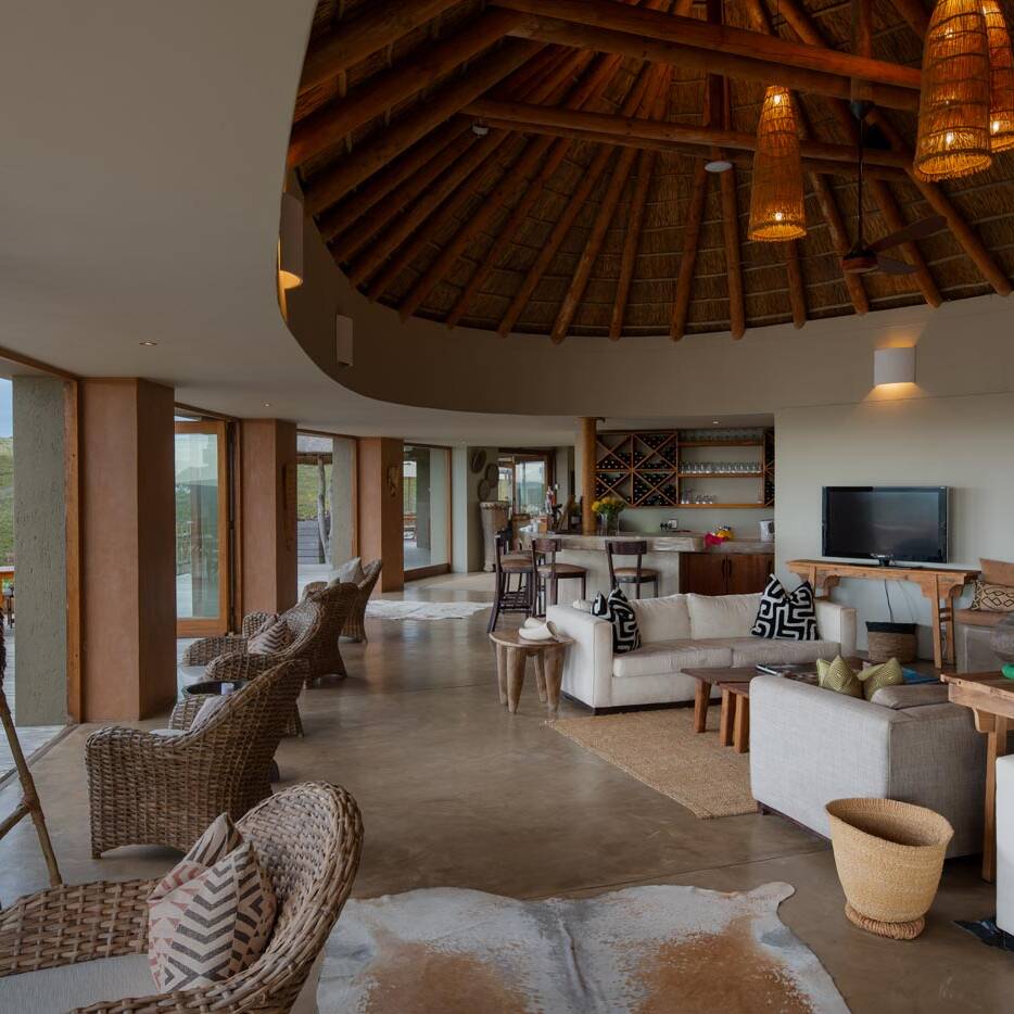 Main lounge with continuous seating and sliding doors to deck, example of Garden Route lodge architecture