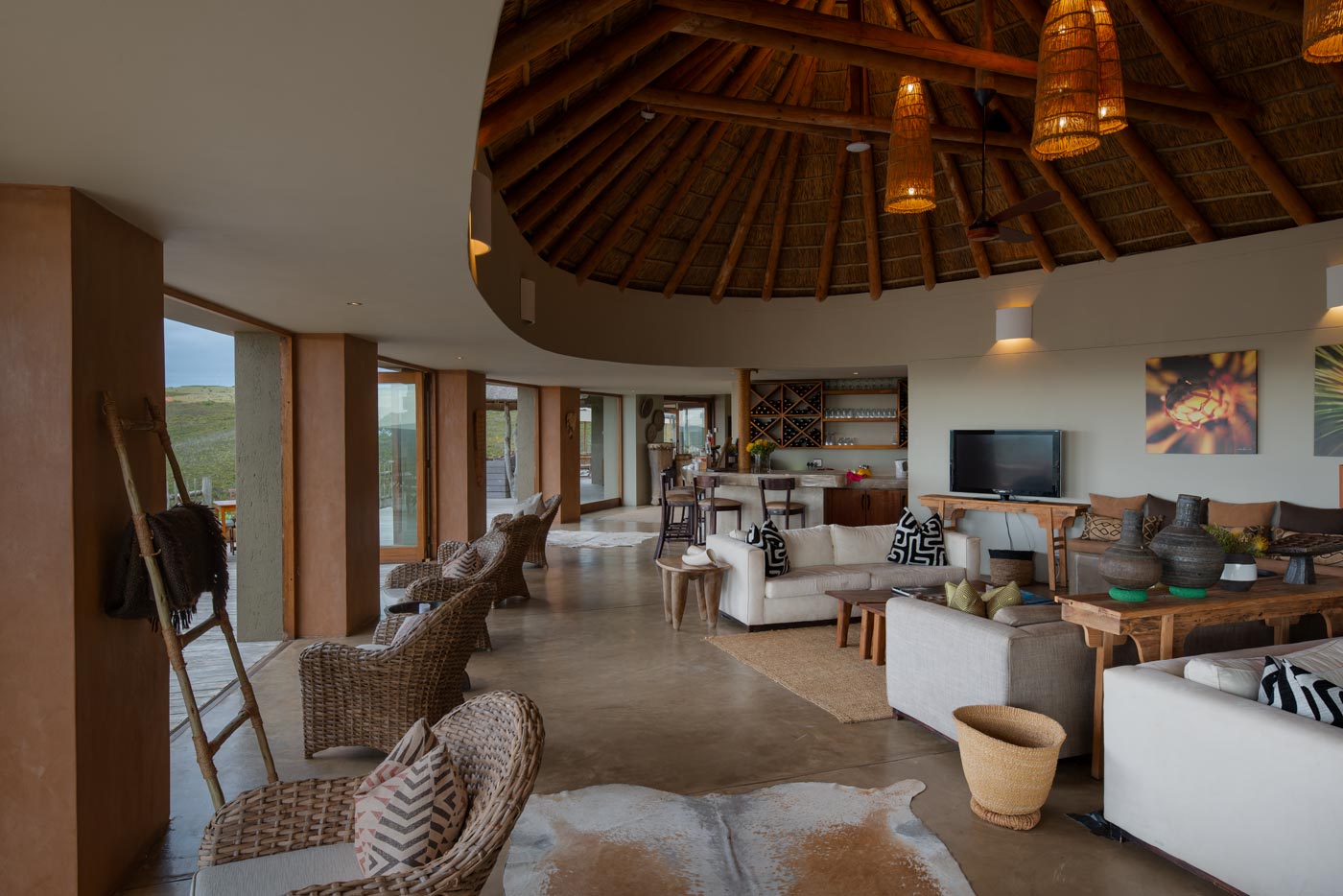 Main lounge with continuous seating and sliding doors to deck, example of Garden Route lodge architecture