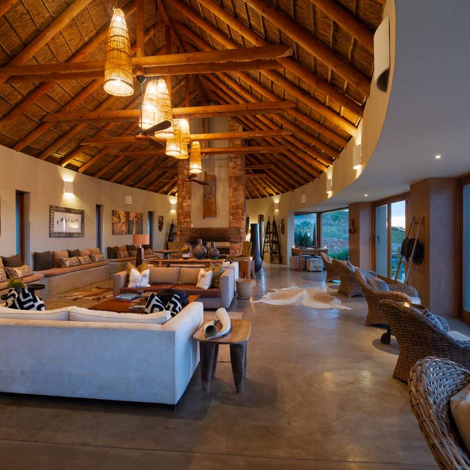 Lodge foyer with thatched roof lanterns and a stone feature wall in the Garden Route