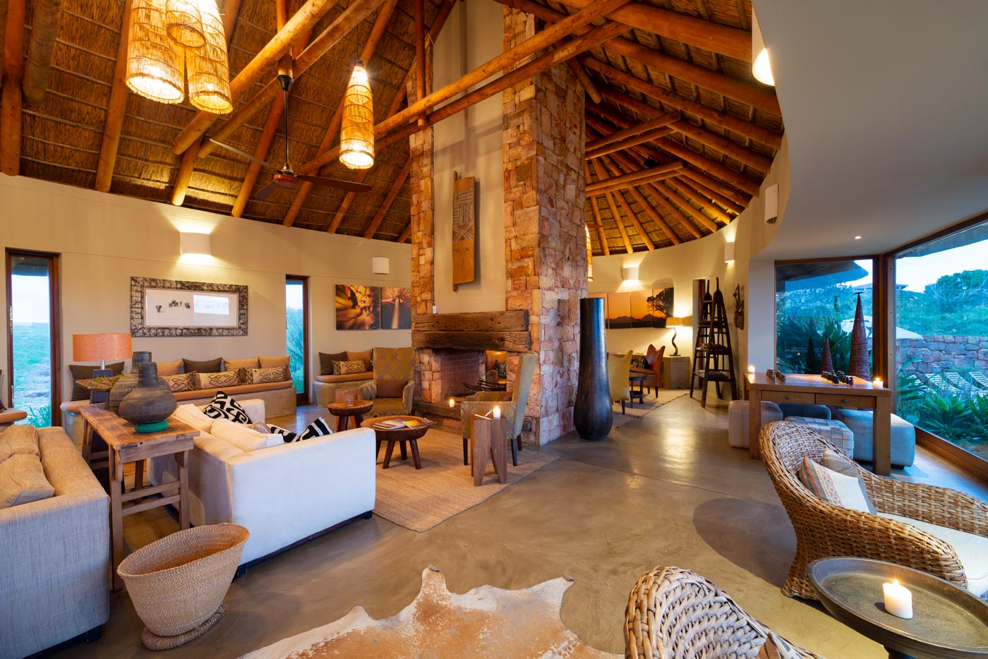 Curved lodge lounge under a thatched roof with woven seating in South Africa