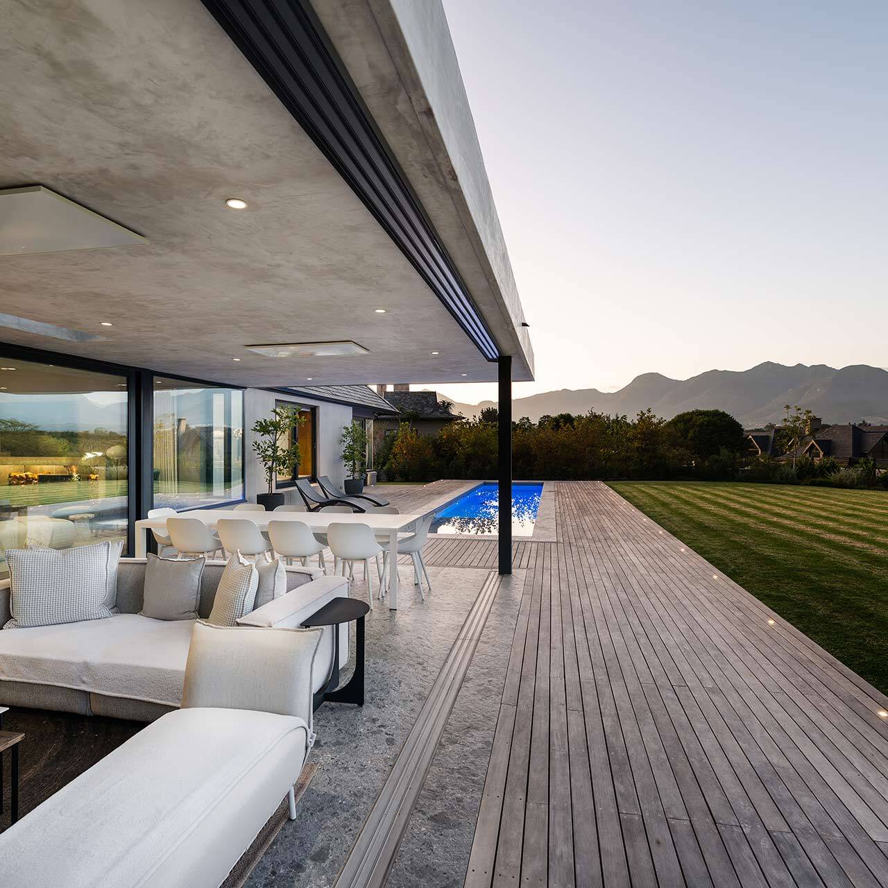 Terrace view along deck and lap pool toward lawn and mountains, House 3002, Fancourt