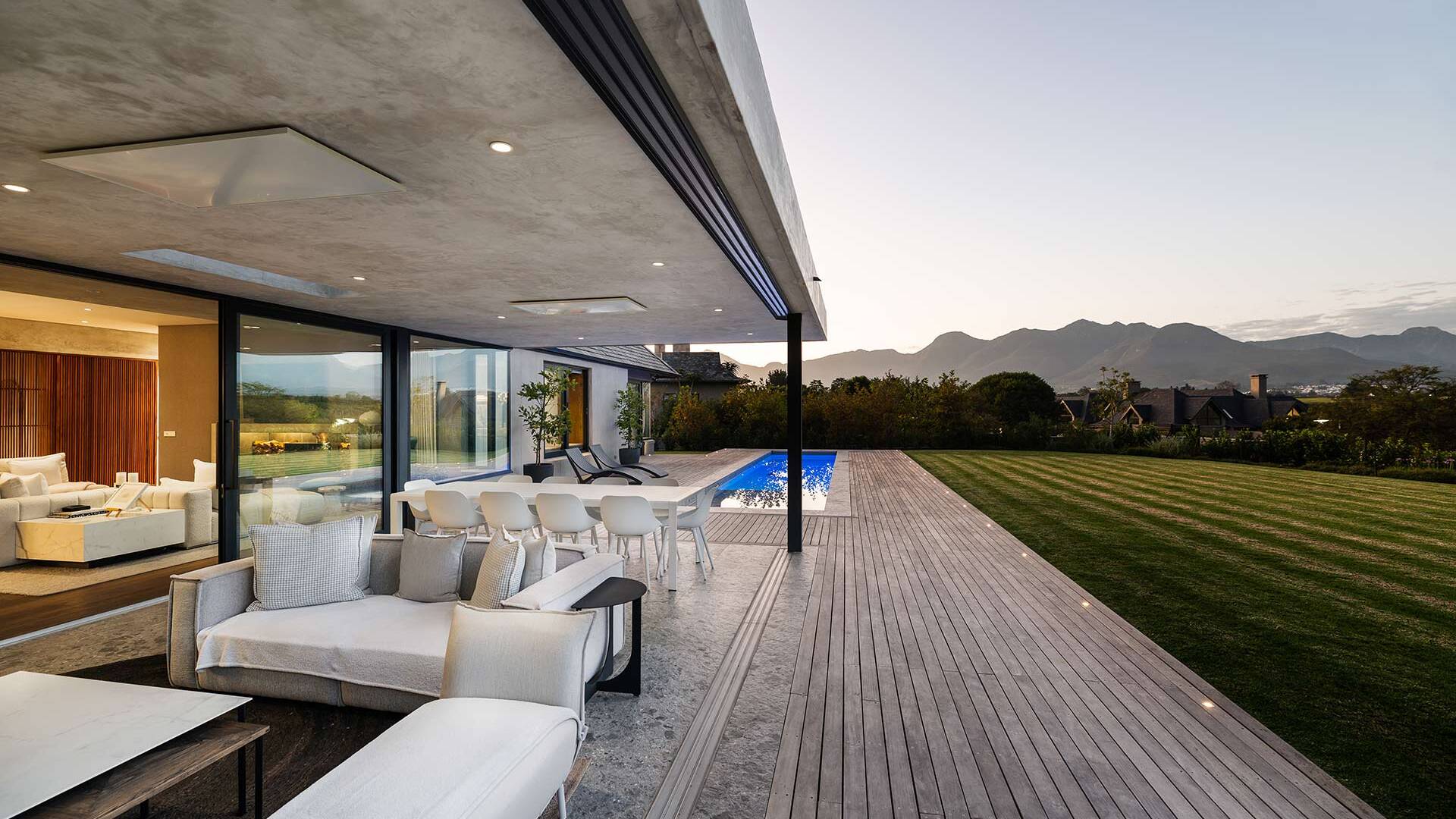 Terrace view along deck and lap pool toward lawn and mountains, House 3002, Fancourt