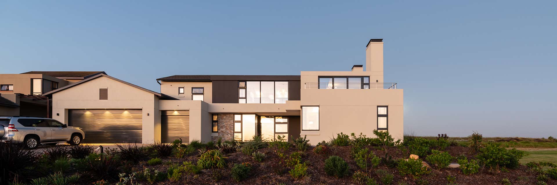 Street-facing facade with layered masses and glazing — golf estate architecture