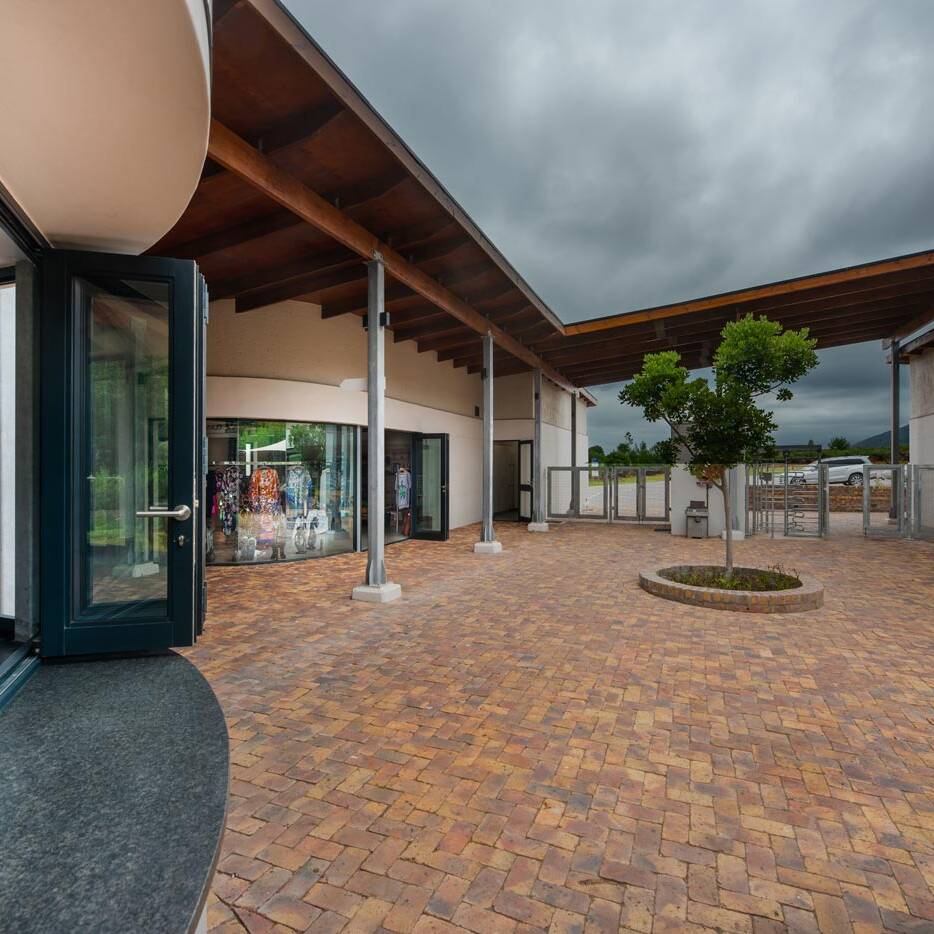Courtyard with folding doors brick paving timber canopy and small tree