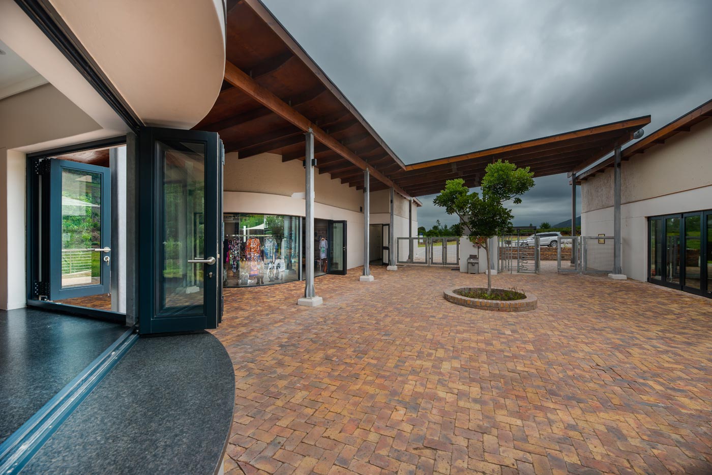 Courtyard with folding doors brick paving timber canopy and small tree